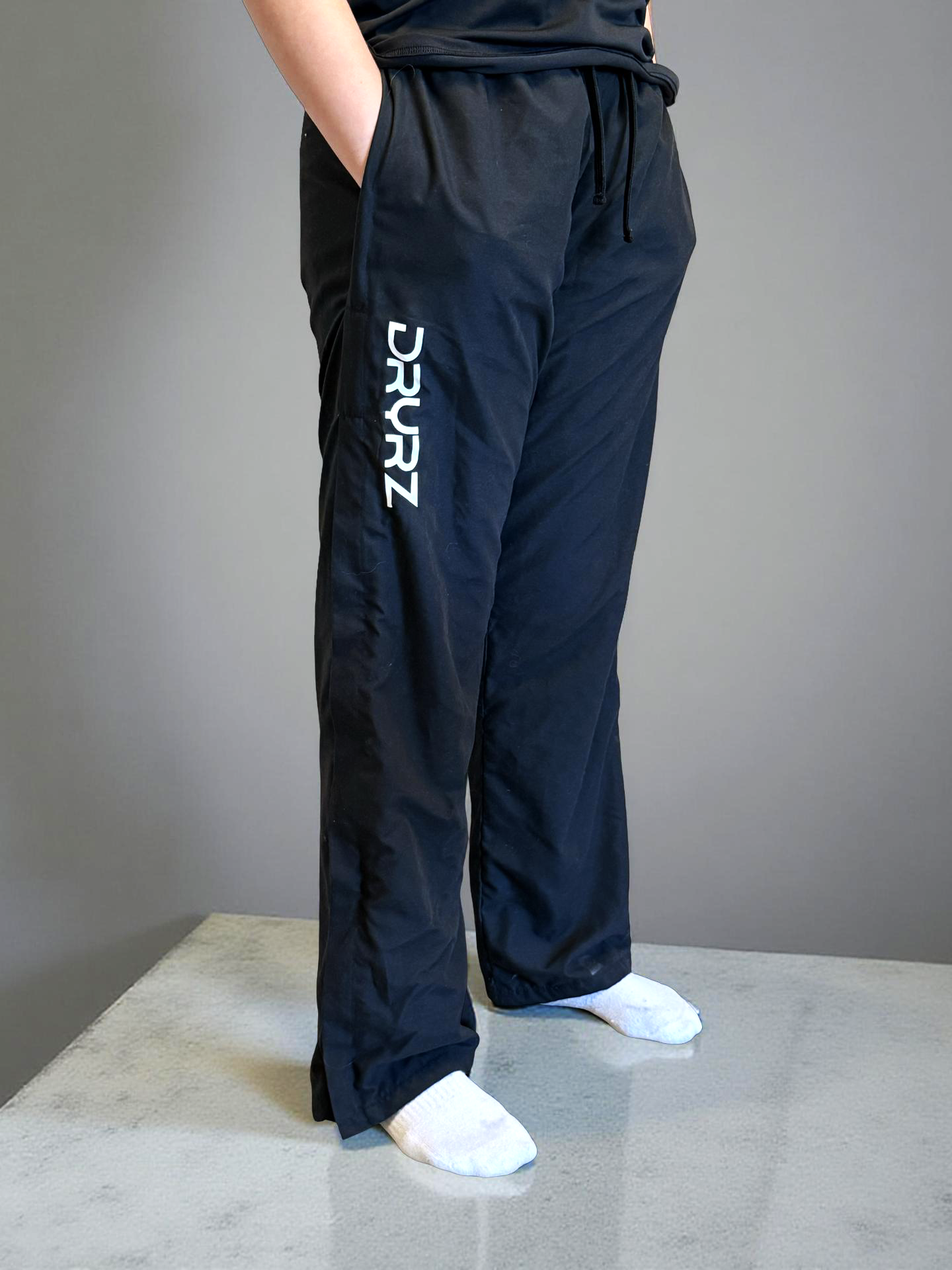 Model standing with hand in deep pocket of DRYRZ thermal joggers, highlighting post-training functionality. Designed for post-workout moisture control.