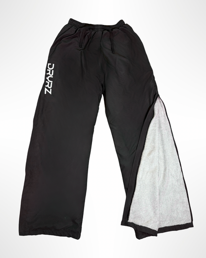 Flat lay front view of DRYRZ BambooLayer thermal trousers, showing logo and design. Detailed fabric close-up of DRYRZ moisture-wicking bamboo-lined recovery joggers, emphasizing soft-touch comfort and post-workout heat retention.
